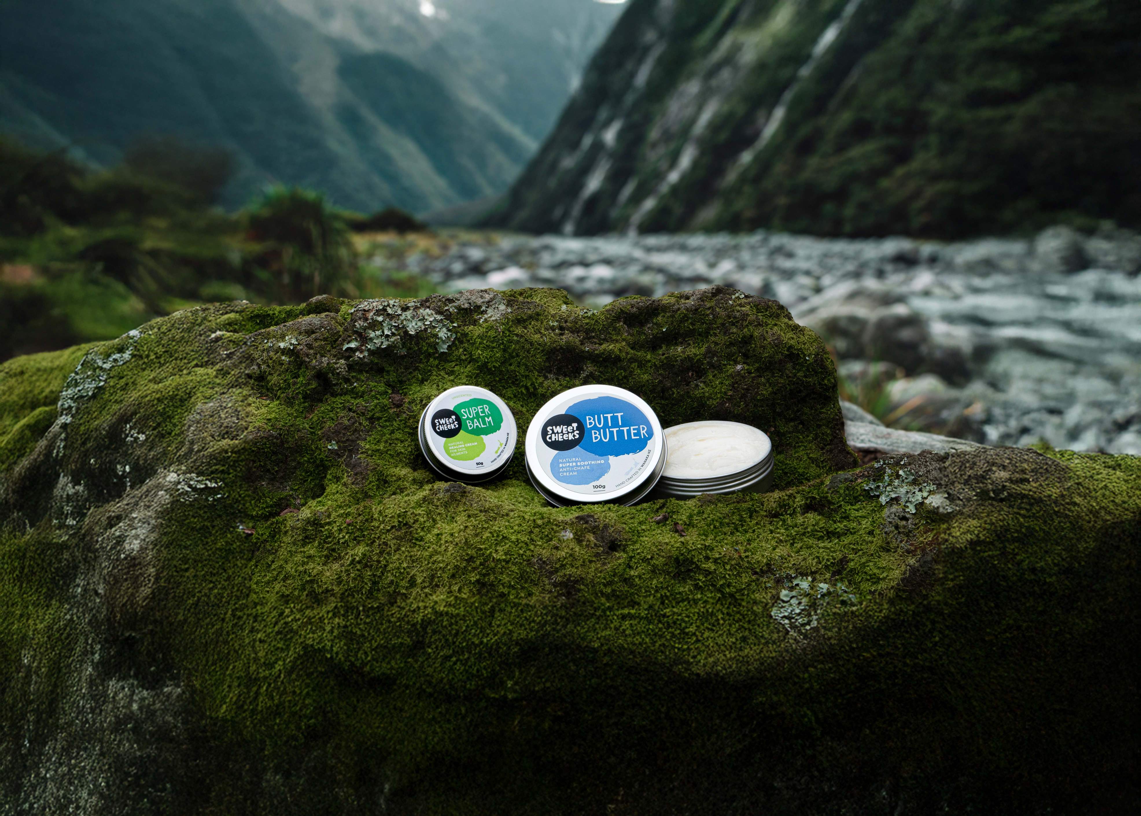 Sweet Cheeks balms on rock with moss 