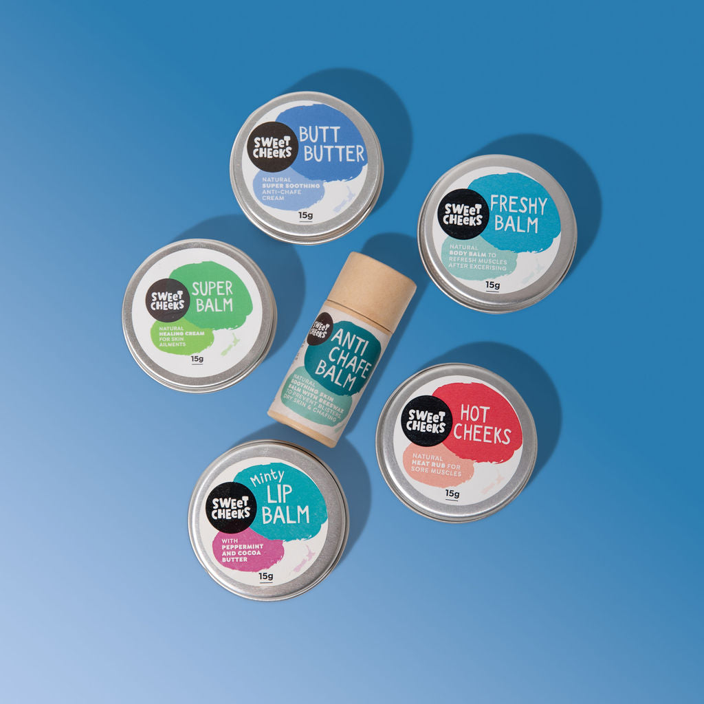 Collection of lip balm tins with colorful labels on a blue background